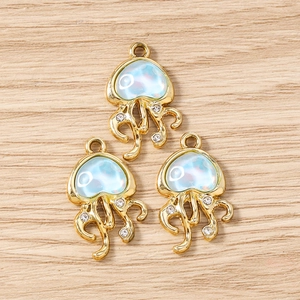 Détail de trois breloques méduses en résine bleue et strass blancs pour bijoux artisanaux