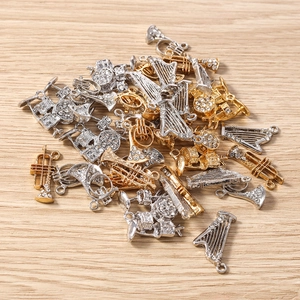 Détail de breloques d'instruments de musique assorties en or et argent avec strass