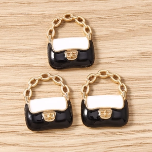 Trois mini pendentifs en forme de sac à main en émail noir et blanc sur bois