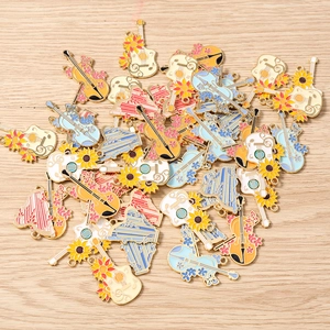 Detailed macro view of enamel musical instrument charms with floral patterns for DIY jewelry