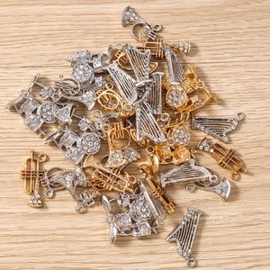 Détail macro de pendentifs instruments de musique avec strass sur fond de bois clair