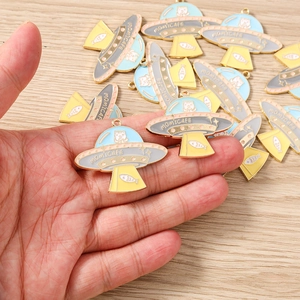 Dettaglio dei ciondoli UFO in colori macaron con motivi di gatto e pesce per il DIY