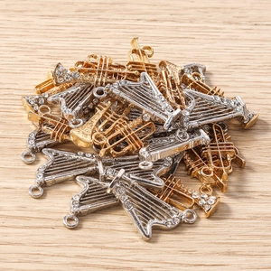 Vue rapprochée de pendentifs instruments de musique dorés et argentés en strass