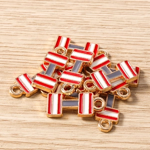 Detalle macro de dijes de pesas coloridos con base de aleación dorada y esmalte para joyería