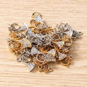 Vue détaillée des pendentifs de cor d'harmonie en or et argent avec strass brillants