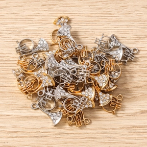 Détail de breloques trompette en or et argent avec strass blancs pour création de bijoux