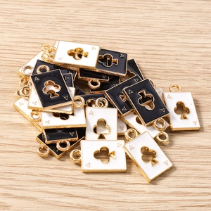 Macro-opname van klaver aas bedeltjes met zwart en wit emaille voor DIY-sieraden