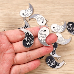 Macro detail of yin yang dragon pendants with black and white enamel finish for DIY jewelry