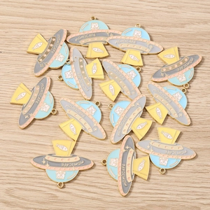 Dettaglio di ciondoli UFO in smalto colorato con motivi di gatti e lische per gioielli DIY