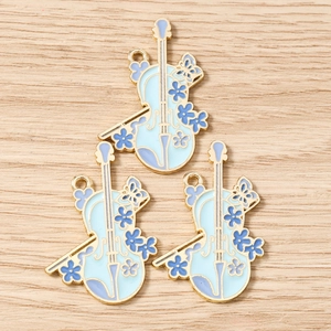 Close-up of enamel violin pendants in blue and purple with golden metal accents