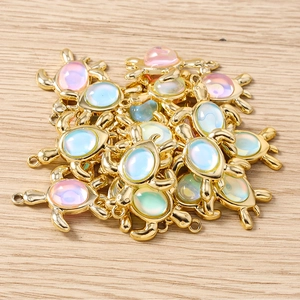 Détail de pendentifs tortue dorés avec résine opale pour la création de bijoux DIY