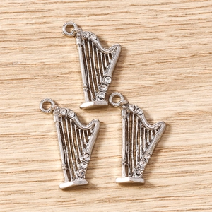 Détail macro de trois breloques harpe en argent avec strass pour bijoux DIY