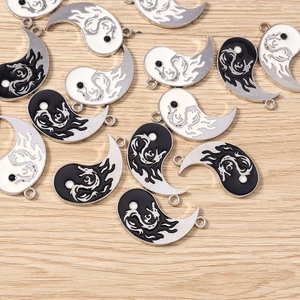 Detail of Yin Yang dragon pendants with black and white enamel finish for DIY jewelry making
