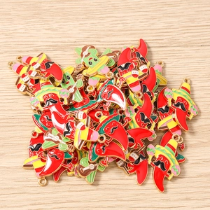 Detail of colorful Mexican style enamel chili and cactus pendants on wooden background