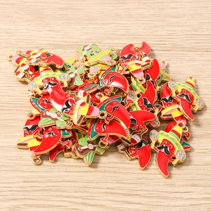 Detail of red chili pepper enamel charms with sombrero and guitar on wood background