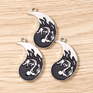 Close-up of silver dragon enamel teardrop charms with black finish for DIY jewelry