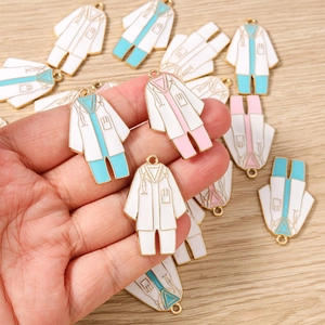Detalle macro de colgantes de aleación con forma de bata médica para joyería de bricolaje
