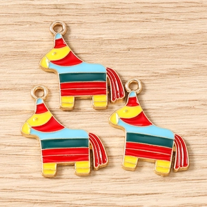 Close-up of three colorful horse pinata enamel charms for DIY jewelry making accessories