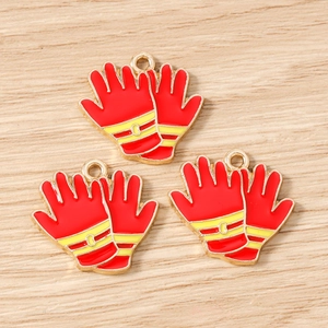 Macro detail of red alloy fire glove charms with gold plating for DIY jewelry making