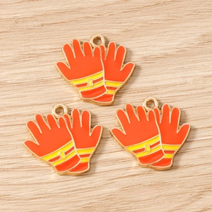 Detail of orange and yellow fire glove charms with golden edges for DIY jewelry making