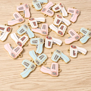 Macro shot of colorful enamel thermometer pendants in white, pink and blue for DIY jewelry