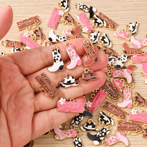 Detailed macro view of cowboy boot and hat enamel charms for DIY jewelry making