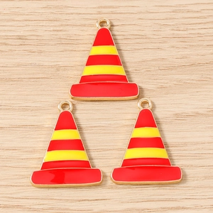Detailed close-up of three traffic cone charms with red and yellow enamel on golden base