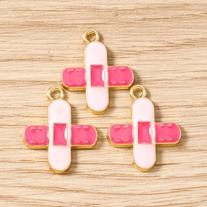 Detail of band-aid shaped enamel alloy pendants with gold plating for jewelry making