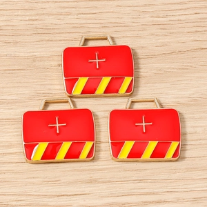 Detailed macro view of red first aid kit charms with white cross for DIY jewelry making