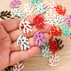 Macro-opname van kleurrijke koraal-emaille bedeltjes met gouden randen voor sieraden