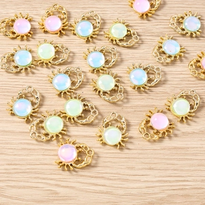 Detail view of gold crab charms with colorful opal stones for DIY jewelry making