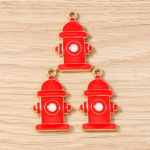 Detailed close-up of fire hydrant shaped red and gold alloy charms for DIY jewelry making