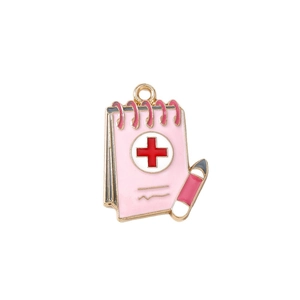 Pink notepad pendant with red cross medical symbol and gold plated enamel finish