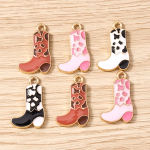 Detailed view of assorted enamel cowboy boot charms in brown, pink, and cow print patterns