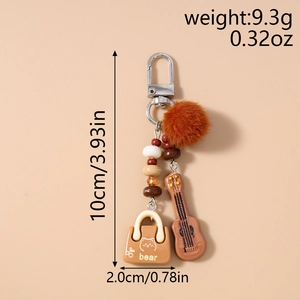 Detail showing guitar charm, plush pompom, and beaded tassel for bohemian keychain