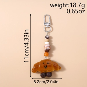 Detail view of cartoon croissant keychain with size measurements and colored beads