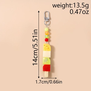 Détail d'un porte-clés esquimau fruité avec perles colorées et fermoir sur fond beige chaud