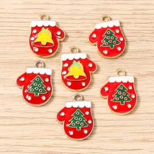 Macro shot of red enamel Christmas glove pendants with festive tree and bell patterns