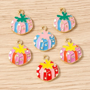 Detailed macro shot of six colorful enamel gift box charms on a wooden surface for DIY jewelry