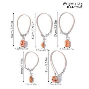 Detailed view of 5-piece faux bread charms set with woven straps and lobster clasps
