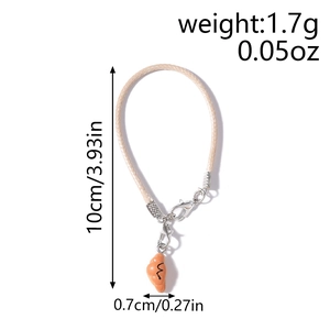Detail showing creative croissant resin pendant with woven cord and lobster clasp for bags