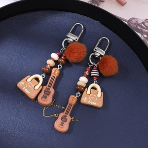 Boho tassel keychain set with plush pom pom, mini guitar charm, and bear bag pendant