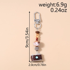 Detail showing the 9cm length and weight of the beaded vintage camera keychain charm