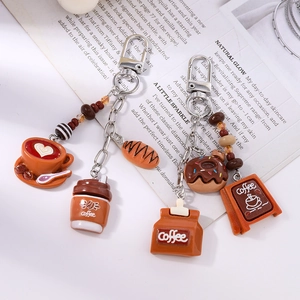 Detail view of coffee and croissant resin keychains with silver metal links and beads