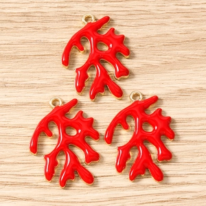 Macro detail van rode emaille koraal tak bedeltjes met gouden legering voor DIY sieraden