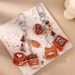 Close-up of coffee and donut miniature charms on a stylish keychain for bags