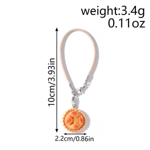 Detail showing artificial tart food pendant with woven lanyard and lobster clasp measurements