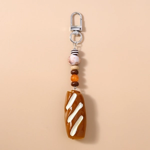 Detailed view of artificial bread keychain with cream coating and colorful decorative beads