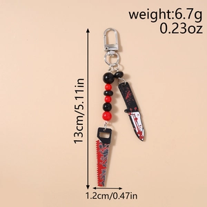 Detail view of Halloween beaded keychain with blood-stained knife and saw charms