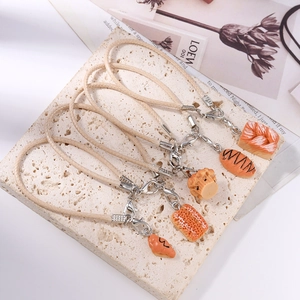 Creative bread-shaped phone charms with croissants and toast on a stone tray
